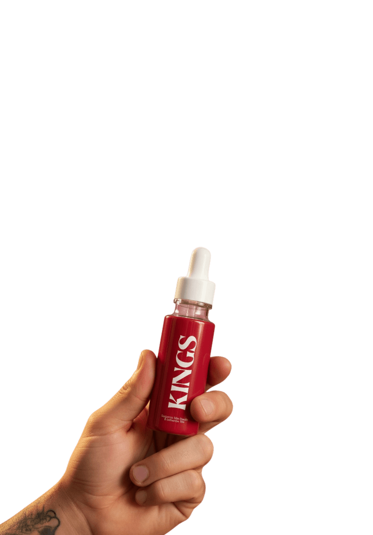 Hand holding Kings Tan Drops bottle